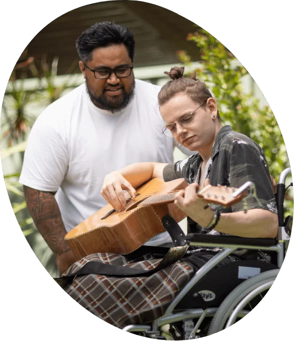Man Teaching Young Man to Play Guitar
