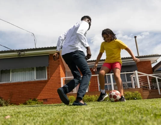 NDIS Staff Playing Football with Kid